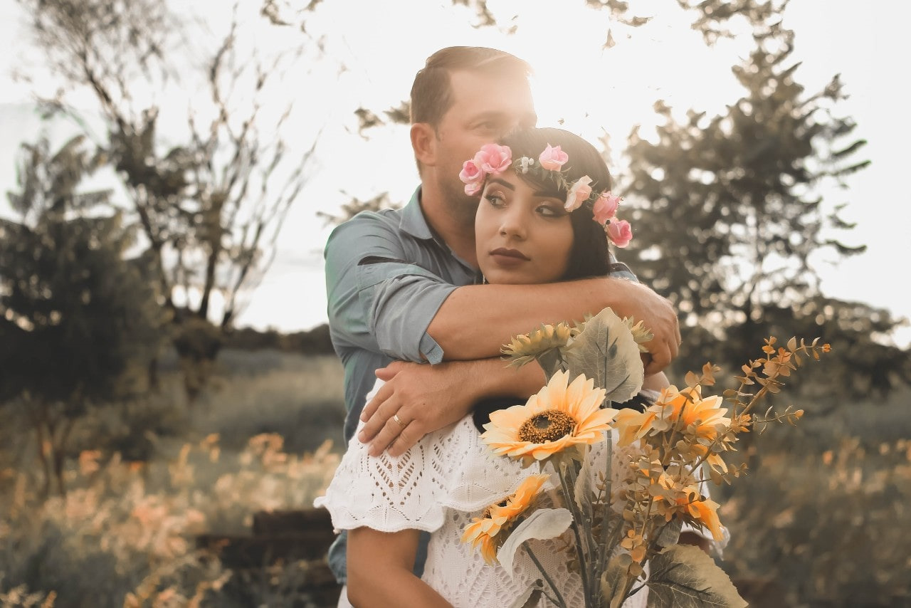 man embracing his bride and wearing a wedding band